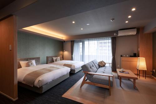 a hotel room with two beds and a couch at Rinn Horikawa Gojo in Kyoto