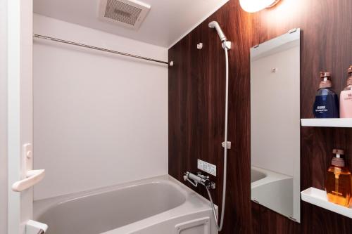 a bathroom with a bath tub and a shower at Rinn Horikawa Gojo in Kyoto