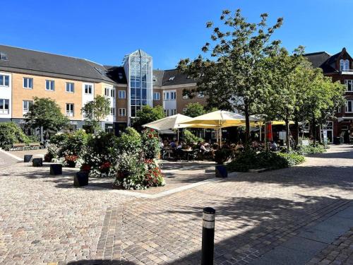 a courtyard with tables and umbrellas and trees at Apartment in the heart of Aalborg in Aalborg
