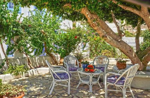 una mesa y sillas sentadas bajo un árbol en Pleiades Alinda Bay Leros, en Alinda
