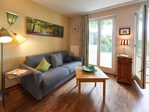 een woonkamer met een blauwe bank en een tafel bij Wohnpark Stadt Hamburg - Apt. 41 in Binz