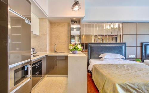 una cucina con letto e lavandino in una camera di Foshan Yumi Apartment Bodun Branch a Foshan