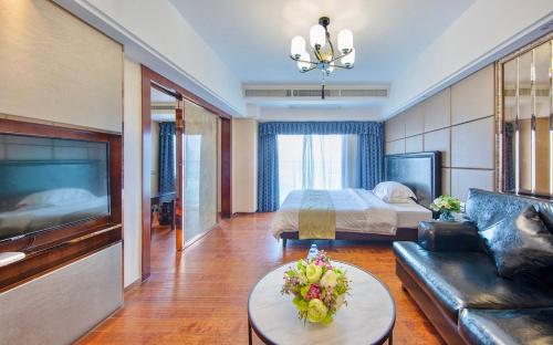 Foshan Yumi Apartment Bodun Branch في فوشان: غرفه فندقيه بسرير واريكه