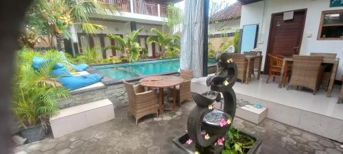 a patio with a table and chairs and a swimming pool at Swara Homestay 2 in Nusa Lembongan