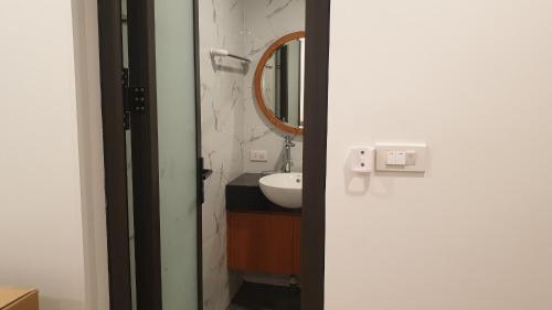 a bathroom with a sink and a mirror at Era Cozy Apartment in Hanoi