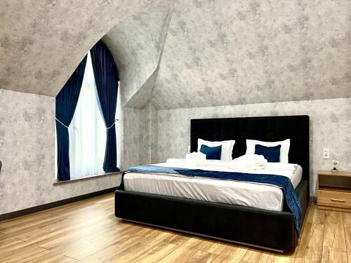 a bedroom with a large bed with a large window at Alpha Plaza Hotel & SPA in Tashkent