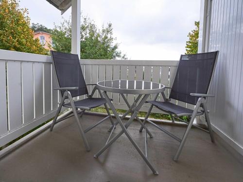 2 Stühle und ein Tisch auf einer Veranda in der Unterkunft Wohnpark Stadt Hamburg - Apt. 39 in Binz