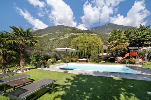 a swimming pool in a yard with mountains in the background at Masulhof Ferienwohnung Löwenzahn in Verdines