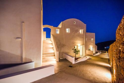 a home with white walls and stairs at night at Makrikythera Luxury Suites - Private Pool or Hot Tub Suites in Dhiakofti
