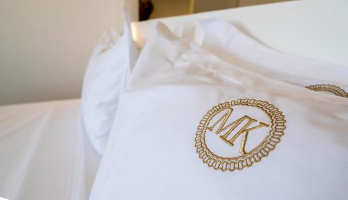a white dress shirt with a gold insignia on it at Makrikythera Luxury Suites - Private Pool or Hot Tub Suites in Dhiakofti