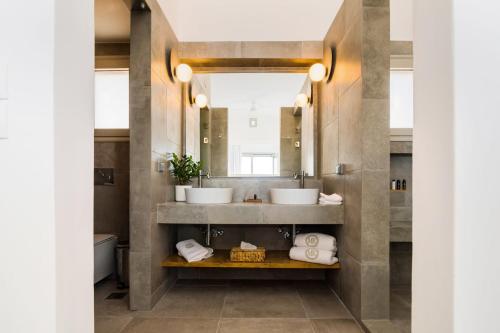 a bathroom with two sinks and a mirror at Makrikythera Luxury Suites - Private Pool or Hot Tub Suites in Dhiakofti