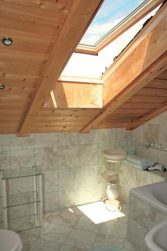 a bathroom with a skylight and a toilet and a sink at Ferienwohnung Goller in Lenggries