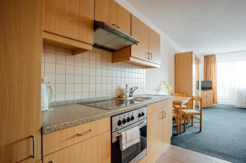 a kitchen with a sink and a stove top oven at Penzión Antares in Zuberec