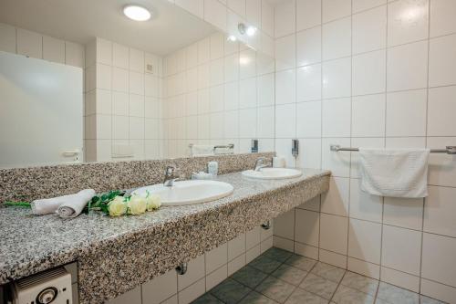 a bathroom with two sinks and a mirror at Penzión Antares in Zuberec