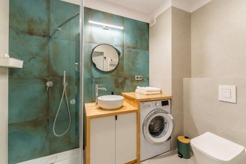 ein Badezimmer mit Dusche und Waschmaschine in der Unterkunft Optima na Wyspie Solnej z parkingiem in Kołobrzeg