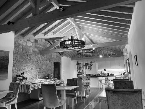 a dining room with a table and chairs and a kitchen at Azenha do Tio Luís in Caminha