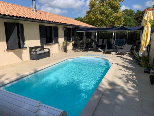 - une piscine en face d'une maison dans l'établissement LA MAISON DES HIPPOCAMPES, à La Teste-de-Buch