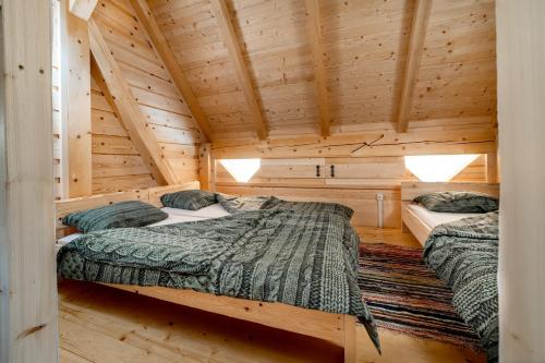 2 camas en una cabaña de madera con paredes de madera en Dormitory and wooden house Beli gaber en Stari Trg pri Ložu