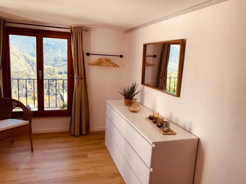 Zimmer mit einer Kommode mit einem Spiegel und einem Fenster in der Unterkunft Casa Mille Sassi in Lionza
