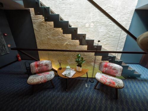 a room with a table and two chairs and a staircase at Villa Lettonia in Jūrmala