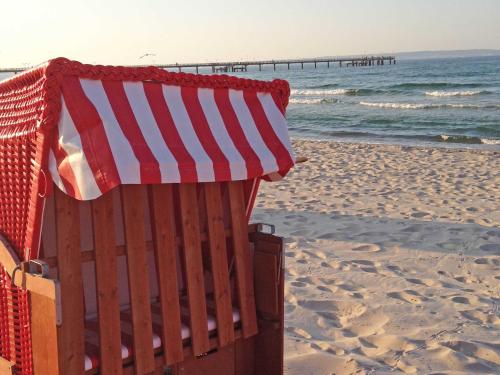 a bench on the beach with an american flag at Wohnpark Stadt Hamburg - Apt. 45 in Binz