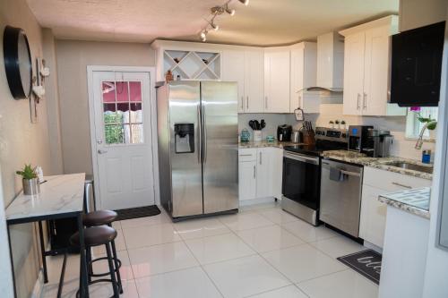 a kitchen with a stainless steel refrigerator at Light & Cozy House in Pompano Beach - BBQ, Patio, Parking in Pompano Beach