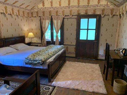 - une chambre avec un lit, une table et une fenêtre dans l'établissement EVAAN RESORTS THE FOLIAGE, à Mukteswar