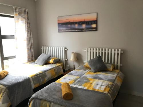a bedroom with two beds and a picture on the wall at Margate Sunset Apartments in Margate