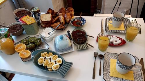 stół ze śniadaniem i napojami w obiekcie Bienvenue w mieście Saint-Pierre-de-Plesguen