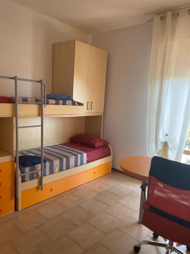 1 Schlafzimmer mit Etagenbetten, einem Schreibtisch und einem Tisch in der Unterkunft Appartamento in Residence Santa Monica in Campomarino