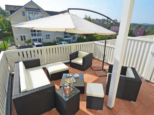a patio with an umbrella and chairs and a table at Wohnpark Stadt Hamburg - Apt. 47 in Binz