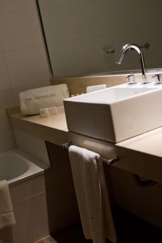 a bathroom with a white sink and a towel at Brizo Neuquén in Neuquén