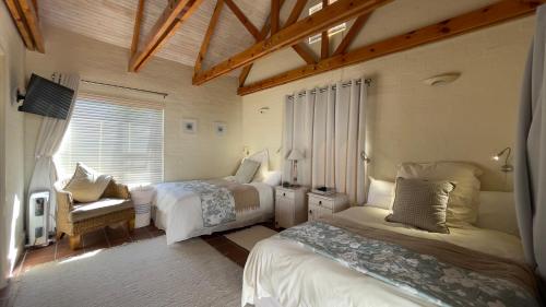 a bedroom with two beds and a window at Villa Paulina in Langebaan