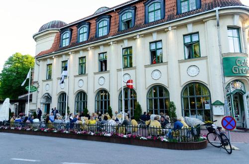 a group of people sitting outside of a building at Hotel Victoria in Pärnu