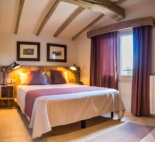 Un dormitorio con una cama grande y una ventana en El Molino de Besalú Casa con jardín, en Besalú