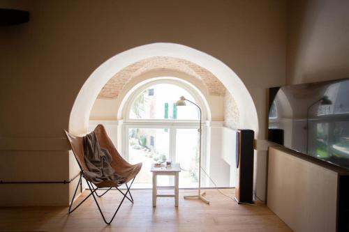 a room with an arched window and a chair and a table at Casa Mon in Monforte dʼAlba
