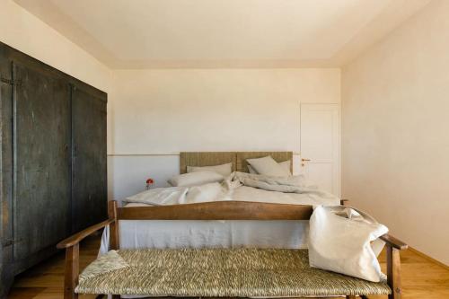 a bedroom with a bed with a bench in it at Casa Mon in Monforte dʼAlba
