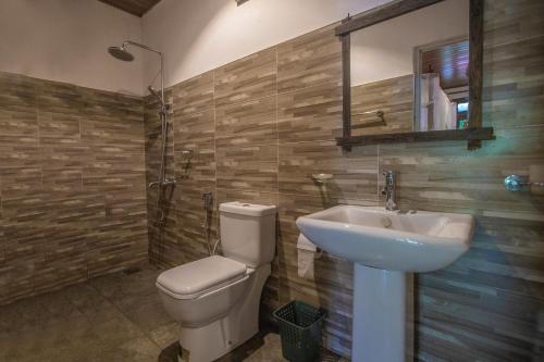 a bathroom with a toilet and a sink at Avenra Cottage in Ella