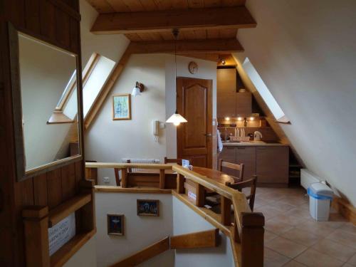 コシチェリスコにあるApartament Księżycowyの階段、テーブル、キッチンが備わる客室です。