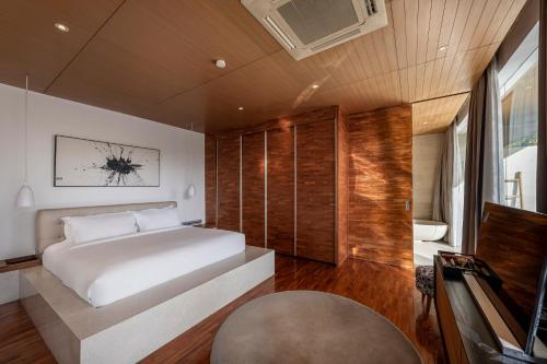 a bedroom with a white bed and a television at One Eleven in Seminyak