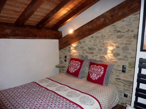 une chambre avec un lit avec des oreillers rouges dans l'établissement Chalet chaleureux à Champagny-en-Vanoise avec sauna 96 m², à Champagny-en-Vanoise