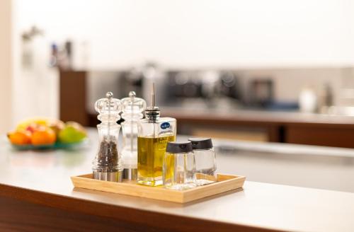a tray with bottles of oil and glasses on a counter at Montreux Rotana Garden House with Private Pool - Swiss Hotel Apartments in Montreux