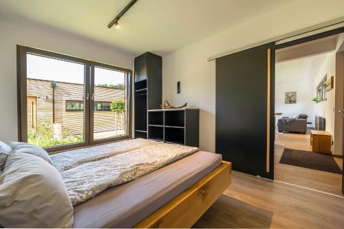 a bedroom with a bed and a large window at Modul Häuser Maurer in Georgenberg