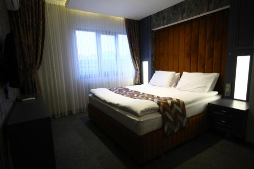 Habitación de hotel con cama y ventana en GRAND DORA HOTEL, en Ankara