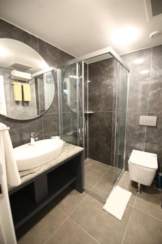 a bathroom with a sink and a shower and a toilet at GRAND DORA HOTEL in Ankara