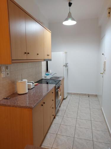 a kitchen with wooden cabinets and a tile floor at ADLER 2 Cozy 2 persons apartment downtown Piraeus in Piraeus