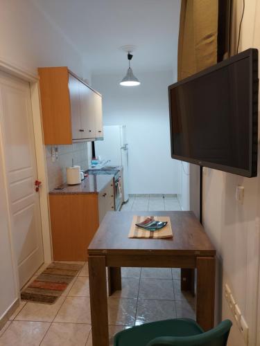 a living room with a table and a flat screen tv at ADLER 2 Cozy 2 persons apartment downtown Piraeus in Piraeus