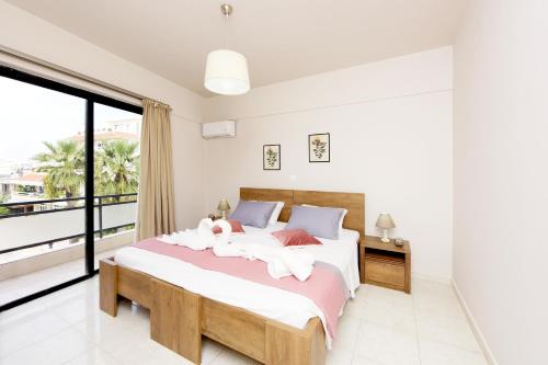 a bedroom with a bed and a large window at Palm Square Appart in Ialysos