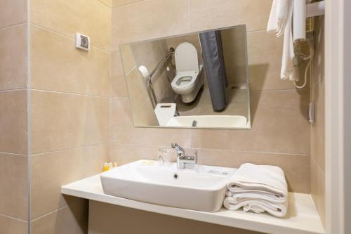 a bathroom with a sink and a toilet at Hotel Verde in Podgorica