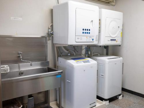 a kitchen with two machines and a sink at Hotel Castle Inn Ise in Ise